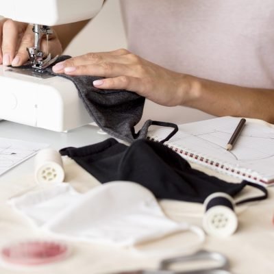 woman-sewing-face-mask-with-notebook
